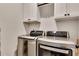 Modern laundry room equipped with stainless steel washer and dryer, complemented by white cabinets for storage at 4732 Cooling Water Cir, Powder Springs, GA 30127