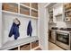 Functional mud room with bench, storage baskets, and coat hooks adjacent to the laundry room with modern washer and dryer at 4732 Cooling Water Cir, Powder Springs, GA 30127