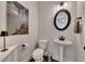 Stylish powder room with pedestal sink, black fixtures, and a desert-themed art piece at 4732 Cooling Water Cir, Powder Springs, GA 30127
