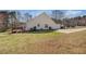 Backyard showcasing home's rear exterior, wooden deck, manicured lawn, and a paved driveway at 109 Melrose Creek Dr, Stockbridge, GA 30281