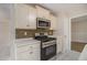 Well-equipped kitchen featuring stainless steel appliances, white cabinets, and mosaic backsplash at 109 Melrose Creek Dr, Stockbridge, GA 30281