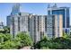 Exterior view of the high-rise condominium with green trees and blue sky at 1101 Juniper Ne St # 519, Atlanta, GA 30309