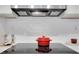 Close up view of modern kitchen cooktop with a red pot, tile backsplash, and stainless vent at 1101 Juniper Ne St # 519, Atlanta, GA 30309