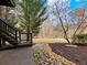 Landscaped backyard with stairs leading to an upper deck, trees, and stone accents at 2536 Kachina Trl, Dacula, GA 30019