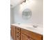 Bright bathroom features a dual sink vanity with wood cabinets beneath a round mirror at 2536 Kachina Trl, Dacula, GA 30019