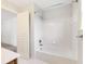 Bathroom featuring a white tiled shower-tub and a doorway opening to the bedroom at 2536 Kachina Trl, Dacula, GA 30019