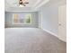 Bright bedroom featuring neutral carpeting, a ceiling fan, and a tray ceiling at 2536 Kachina Trl, Dacula, GA 30019