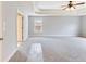 Spacious bedroom featuring neutral carpeting, a ceiling fan, and a tray ceiling at 2536 Kachina Trl, Dacula, GA 30019