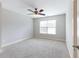 Neutrally painted bedroom with carpet flooring features a modern ceiling fan and window at 2536 Kachina Trl, Dacula, GA 30019