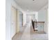 Bright hallway featuring neutral carpeting, white walls and doors, and a staircase with black metal railings at 2536 Kachina Trl, Dacula, GA 30019
