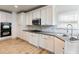 Bright kitchen features white cabinets, stainless appliances, tile backsplash, and hardwood floors at 2536 Kachina Trl, Dacula, GA 30019
