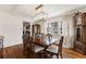 Elegant dining room featuring a large wooden table, modern lighting, and views of the backyard at 2630 Orchard Knob Se, Atlanta, GA 30339