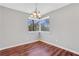 Cozy dining area with hardwood floors, neutral paint, a chandelier, and a large window with wooded views at 3136 Taffy Ln, Snellville, GA 30039