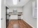 Galley kitchen features white cabinets, stainless appliances, and wood look flooring at 3136 Taffy Ln, Snellville, GA 30039