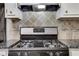 This kitchen features an updated range, tile backsplash and granite countertops at 3136 Taffy Ln, Snellville, GA 30039