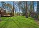 Lush backyard featuring mature trees and a deck area for outdoor entertaining at 4453 Abingdon Dr, Stone Mountain, GA 30083