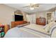 Cozy bedroom featuring wood furniture, ceiling fan, and comfortable neutral-toned bedding at 4453 Abingdon Dr, Stone Mountain, GA 30083