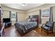 Bedroom with hardwood floors, a dark wooden bed frame, and window views at 4453 Abingdon Dr, Stone Mountain, GA 30083