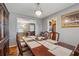 Formal dining room featuring a large wooden table, wood floors and a lovely light fixture at 4453 Abingdon Dr, Stone Mountain, GA 30083