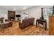 Cozy living room with brick fireplace, wood floors, and natural light, with leather reclining furniture at 4453 Abingdon Dr, Stone Mountain, GA 30083
