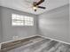 Bedroom featuring a window, ceiling fan, and gray wood-look flooring at 4701 Flat Shoals Rd # 49C, Union City, GA 30291