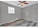 Bright bedroom with a window, ceiling fan, and gray wood-look flooring at 4701 Flat Shoals Rd # 49C, Union City, GA 30291