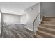 Open-concept living room with carpeted staircase and stylish gray wood-look flooring at 4701 Flat Shoals Rd # 49C, Union City, GA 30291