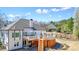 Expansive backyard featuring a multi-level deck, complete with a dining area, pergola, and serene wooded views at 1090 Compton Way, Suwanee, GA 30024