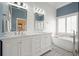Bright bathroom features a double vanity, soaking tub, and shiplap accents at 1090 Compton Way, Suwanee, GA 30024