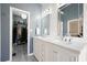 Elegant bathroom vanity with double sinks, decorative mirrors and adjacent closet at 1090 Compton Way, Suwanee, GA 30024