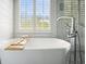 Bright bathroom featuring a soaking tub with a window and a stylish faucet at 1090 Compton Way, Suwanee, GA 30024