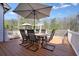 Outdoor deck with dining table, umbrella, and white railing; perfect for enjoying warm weather at 1090 Compton Way, Suwanee, GA 30024