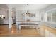 Spacious dining area with hardwood floors, stylish chandelier, bench seating, and abundant natural light at 1090 Compton Way, Suwanee, GA 30024