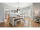 Dining area with a wooden table, bench seating, chandelier, and large windows at 1090 Compton Way, Suwanee, GA 30024