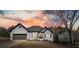 Charming home with a brick exterior, two-car garage, and landscaped front yard at sunset at 1090 Compton Way, Suwanee, GA 30024