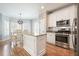Bright eat-in kitchen area boasts white cabinetry, granite island, stainless steel appliances, and a pantry at 1090 Compton Way, Suwanee, GA 30024