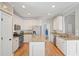 Well-appointed kitchen with white cabinetry, granite countertops, stainless steel appliances, and center island at 1090 Compton Way, Suwanee, GA 30024