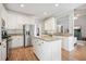 Spacious kitchen with a large island, granite countertops, white cabinets, and stainless steel appliances at 1090 Compton Way, Suwanee, GA 30024