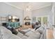 Bright living room featuring a white brick fireplace, a large sectional, and doors leading to outdoor space at 1090 Compton Way, Suwanee, GA 30024