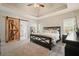 Main bedroom features a tray ceiling, a rustic sliding barn door to the bathroom, and carpeted floors at 1090 Compton Way, Suwanee, GA 30024