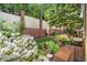 Landscaped backyard with white flowers, a fountain, and a brick retaining wall at 3582 Grove Gate Ln, Atlanta, GA 30339