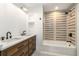 Stylish bathroom with double sinks, a wood vanity, and tiled shower over tub at 3582 Grove Gate Ln, Atlanta, GA 30339