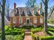 Beautiful brick home with a dormered roof, complimented by lush green landscaping and a brick walkway at 3582 Grove Gate Ln, Atlanta, GA 30339