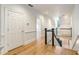 Bright hallway with wood floors and white trim leads to the staircase with wainscotting at 3582 Grove Gate Ln, Atlanta, GA 30339
