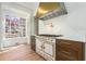 Beautiful white kitchen features a range with a pot filler and custom hood at 3582 Grove Gate Ln, Atlanta, GA 30339