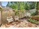 Charming stone patio featuring two outdoor chairs, a lattice fence, and lush greenery at 3582 Grove Gate Ln, Atlanta, GA 30339