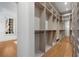 Spacious walk-in closet with custom shelving, mirrored wall, and hardwood floors provides elegant storage at 3582 Grove Gate Ln, Atlanta, GA 30339