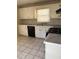Traditional kitchen with white cabinets, black appliances, and tiled floors at 1415 Dodson Sw Dr, Atlanta, GA 30311