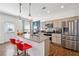 Modern kitchen featuring a granite island with seating, stainless appliances and a door to the back yard at 1484 Ben Park Way, Grayson, GA 30017