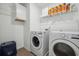 Clean laundry room with washer, dryer, storage shelves and sleek wood-look floors at 1484 Ben Park Way, Grayson, GA 30017